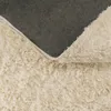 A close-up view of the texture of a rug, showing the fluffy pile and the backing. Produktbild-Vorschau