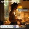 A woman cooking in a kitchen, with a speech bubble indicating voice control. Produktbild-Vorschau