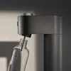 A close-up shot of a soda maker with a glass bottle being inserted. Produktbild-Vorschau