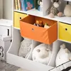 A close-up view of a white children's bookshelf with various storage compartments and toys. Anteprima dell’immagine prodotto