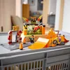 A LEGO City Stunt Park set with a motorcycle, ramp, and obstacles is displayed on a gray surface. Podgląd zdjęcia produktu