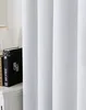 A close-up view of a white curtain with a stack of books on a nightstand to the left. Produktbild-Vorschau