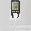 A black energy meter plugged into a white wall socket, with a white power cord extending downwards. Náhled obrázku produktu