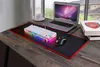 A gaming keyboard and mouse setup on a wooden desk with a laptop and books. Produktbild-Vorschau