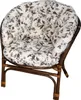 A close-up studio shot of a rattan chair with floral cushions. Náhled obrázku produktu