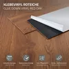 A close-up view of vinyl flooring planks with the backing peeled off to show the adhesive. Náhled obrázku produktu