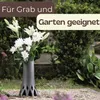A vase with white flowers in a garden or cemetery setting. Produktbild-Vorschau