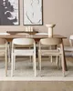 A dining room scene with a wooden table and chairs, artwork on the wall, and a rug on the floor. Produktbild-Vorschau