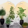 A white LED plant grow light stand with multiple adjustable heads illuminates several potted indoor plants. Produktbild-Vorschau
