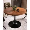 A round wooden dining table with a black pedestal base is shown in a dining room setting, with chairs and a rug visible. Anteprima dell’immagine prodotto