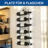 A black metal wine rack with six bottles of wine mounted on a textured wall. Produktbild-Vorschau