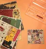 A collection of wooden puzzle sheets and a clear plastic tray are laid out on an orange surface. Podgląd zdjęcia produktu