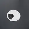 A close-up view of a desk grommet on a dark surface. Náhled obrázku produktu