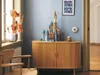 A LEGO Disney castle is displayed on a wooden cabinet in a room with blue walls. Náhled obrázku produktu