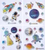 A collage of four quadrants, each featuring various space-themed stickers with glittery accents. Produktbild-Vorschau