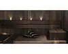 A dimly lit sauna with wooden walls and benches, featuring subtle lighting and two striped pillows. Produktbild-Vorschau
