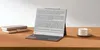 A tablet with a keyboard case, books, and a cup of coffee on a wooden desk. Náhľad obrázku produktu