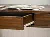 A close-up view of a wooden desk with an open drawer and a book on top. Anteprima dell’immagine prodotto