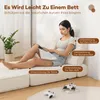 A woman is sitting on a white sofa bed, reading a book. The sofa is in a room with a plant and a rug. There are annotations on the image highlighting support areas. Podgląd zdjęcia produktu