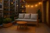 A balcony with a sofa, coffee table, and plants, illuminated by string lights. Voir les images du produit