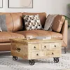 A coffee table in front of a leather couch with pillows and a blanket. Produktbild-Vorschau
