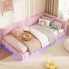 A pink corner bed with multiple pillows and blankets, decorated in a child's room with a rug and a picture on the wall. Náhled obrázku produktu