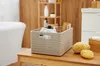 A bathroom setting with a bathtub, shelving, and a storage basket on a wooden surface. Anteprima dell’immagine prodotto