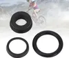 A cyclist in the background, with three black bicycle brake parts in the foreground. Anteprima dell’immagine prodotto
