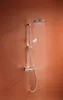 A chrome shower system with water running from the showerhead, set against a textured orange-brown wall. Anteprima dell’immagine prodotto