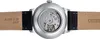 The back of a watch with its movement visible through a transparent case back, attached to a black leather strap. Produktbild-Vorschau