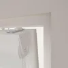 A close-up view of the top mechanism and cassette of a white roller blind, mounted inside a window frame. Produktbild-Vorschau