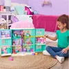 A young girl plays with a dollhouse in a bedroom setting. Náhľad obrázku produktu
