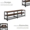 A long, multi-shelf industrial-style TV stand with a dark wood grain finish and black metal frame is shown from a slightly elevated side angle. Text descriptions highlight its design and construction. Náhled obrázku produktu