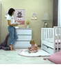 A mother reads a book to her child in a nursery room. Anteprima dell’immagine prodotto