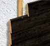 Close-up view of dark wood siding being attached to a wall with a wooden stud. Produktbild-Vorschau