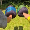 Two hands wearing padded gloves outdoors on a grassy area. Produktbild-Vorschau
