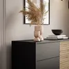 A close-up view of a modern dresser with decorative items on top. Produktbild-Vorschau
