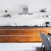 A modern kitchen with a stainless steel range hood mounted on a white brick wall above a wooden cabinet base. Produktbild-Vorschau