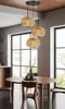 A dining room with a round wooden table and chairs, illuminated by a pendant light. Náhled obrázku produktu