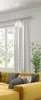 A modern living room with a yellow sectional sofa, grey and beige throw pillows, a large window with white curtains, and a plant. Produktbild-Vorschau