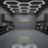 A modern garage interior with hexagonal LED lighting on the ceiling and shelves stocked with cleaning supplies. Podgląd zdjęcia produktu