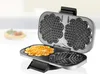 A waffle maker with two heart-shaped waffle plates, one with a freshly made heart-shaped waffle on it. Produktbild-Vorschau