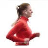 A woman is running outdoors, wearing a red athletic top and white earbuds. Produktbild-Vorschau