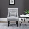 A gray armchair with a small pillow sits on a gray rug in front of a dark gray wall. A small white side table with a plant and a cup is to the right of the chair. Voir les images du produit