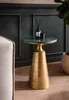 A small round table with a marble top and a gold base, placed next to a sofa in a room with dark green paneled walls. Produktbild-Vorschau