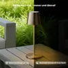 A portable LED table lamp is shown on a wooden table outdoors, with a split image showing daytime and nighttime settings. Podgląd zdjęcia produktu