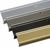 Four metal stair nosing profiles in different colors are arranged diagonally. Podgląd zdjęcia produktu