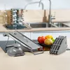 A kitchen counter with a mandoline slicer, a food holder, and some vegetables. Produktbild-Vorschau