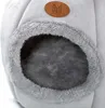Close-up of a grey plush pet bed with a brown logo. Podgląd zdjęcia produktu