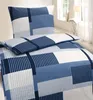 A close-up view of a bedding set with a geometric pattern, placed on a bed near a window. Produktbild-Vorschau